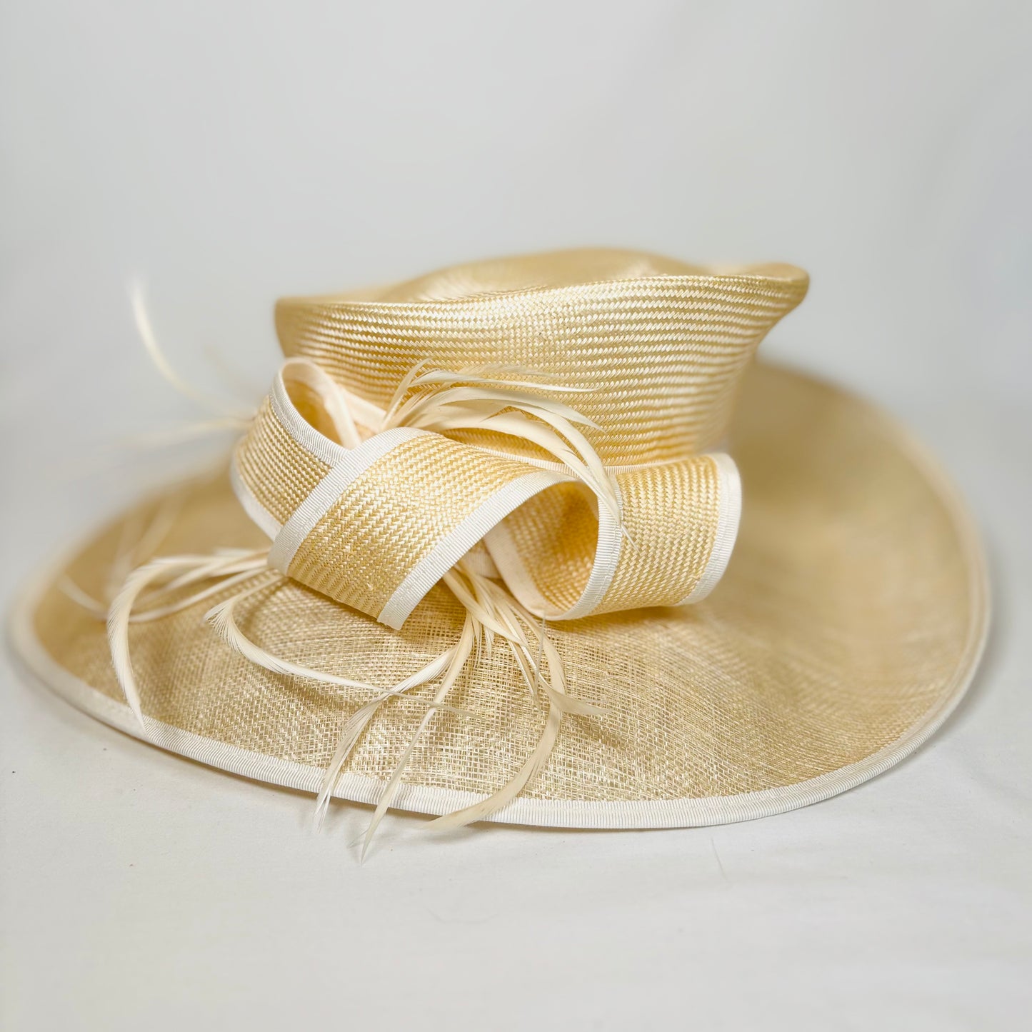 Cream straw occasion hat with light trim and statement bow design