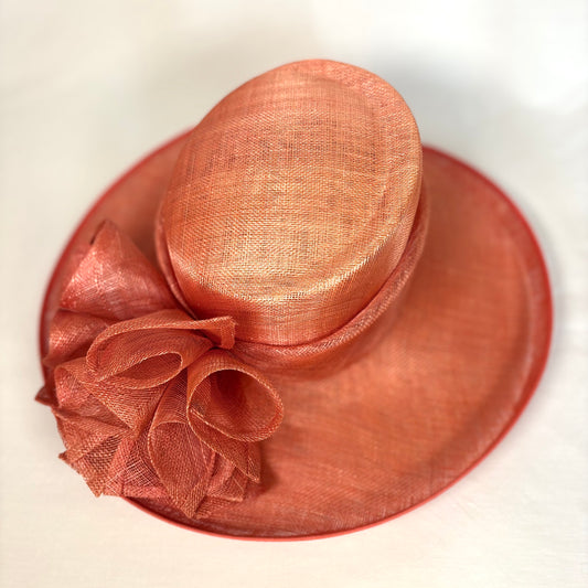Orange wide-brim statement occasion hat with sculpted ribbon design