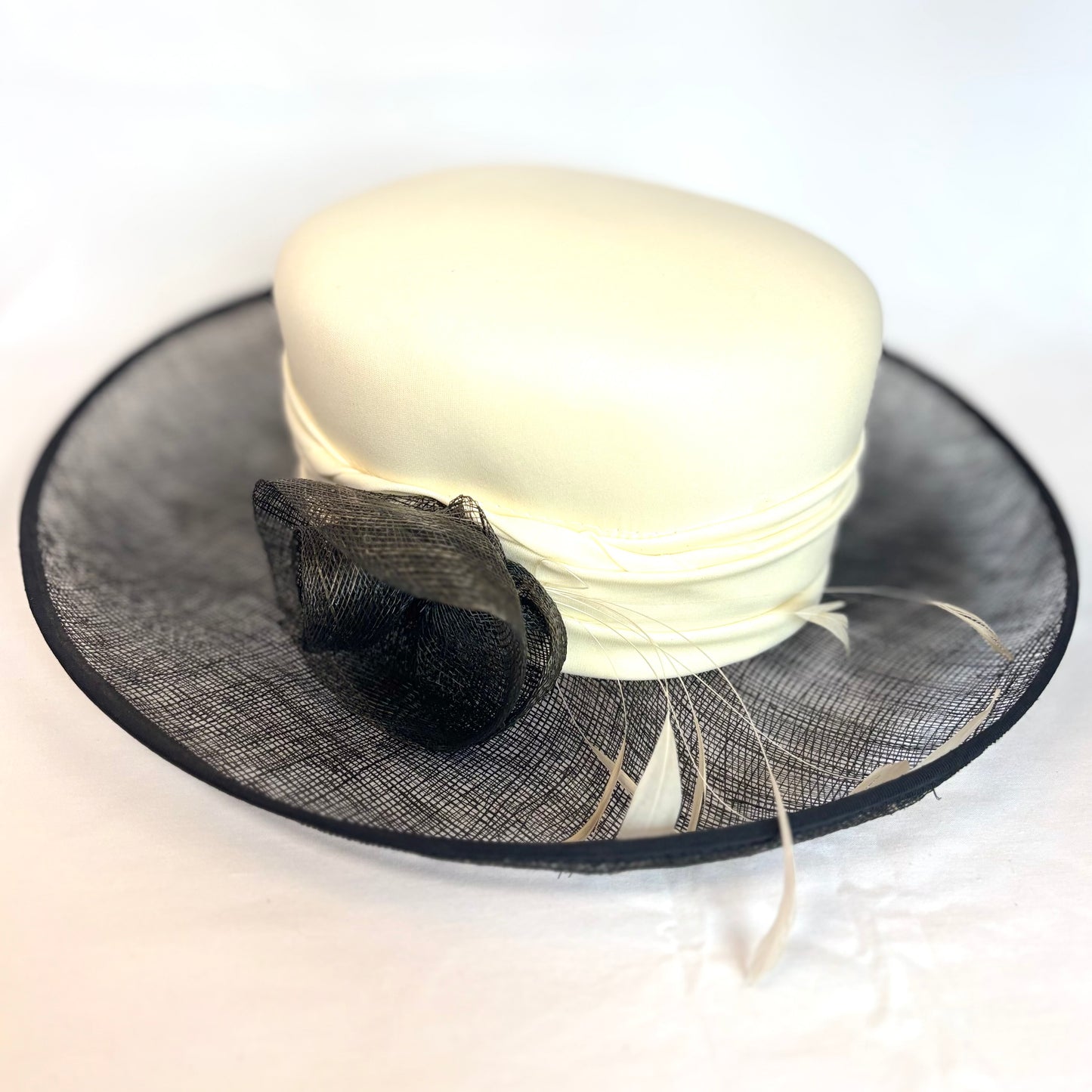 Black and white soft occasion hat with feather and flower design