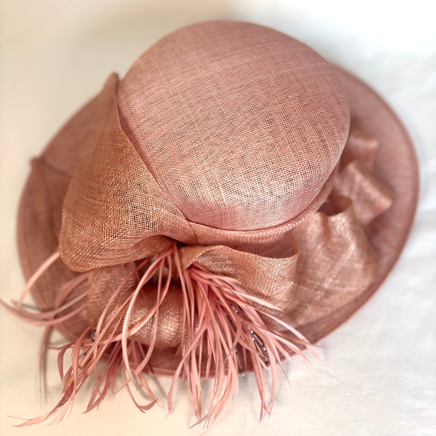 Blush feathered occasion hat with sculpted ribbon detail