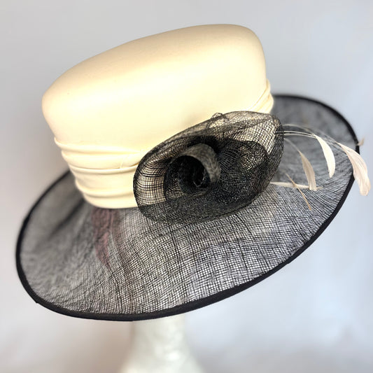Black and white soft occasion hat with feather and flower design