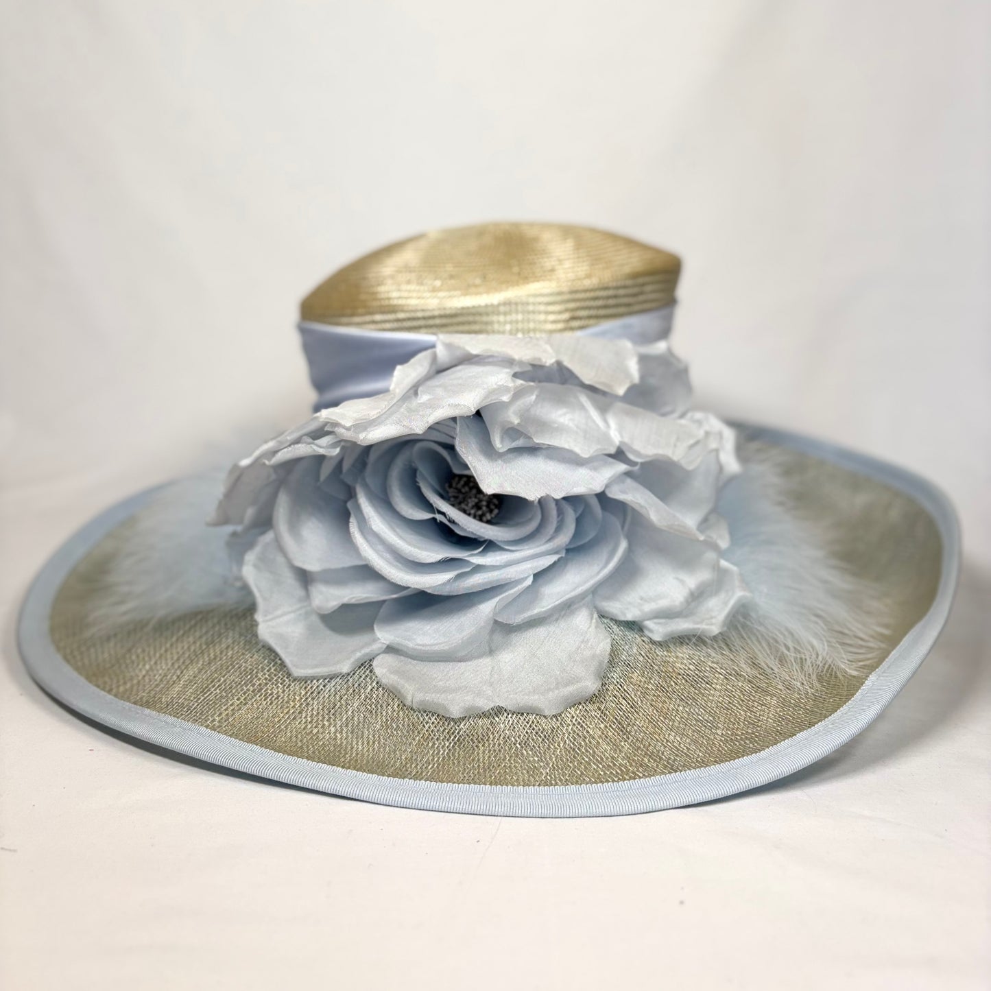 Wide-brim straw hat with pale blue feature flower design.