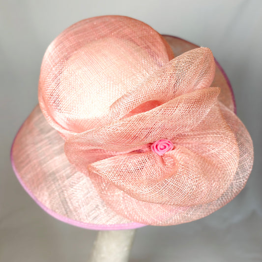 Pink wide brim occasion hat with textured flower design