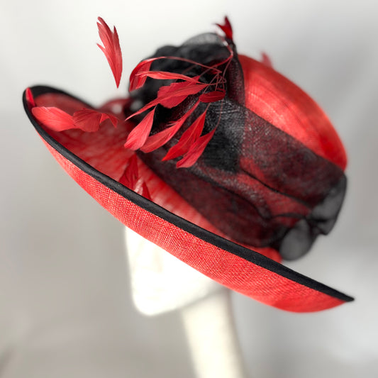 Red and black statement hat with bow and feather design