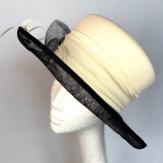 Black and white soft occasion hat with feather and flower design